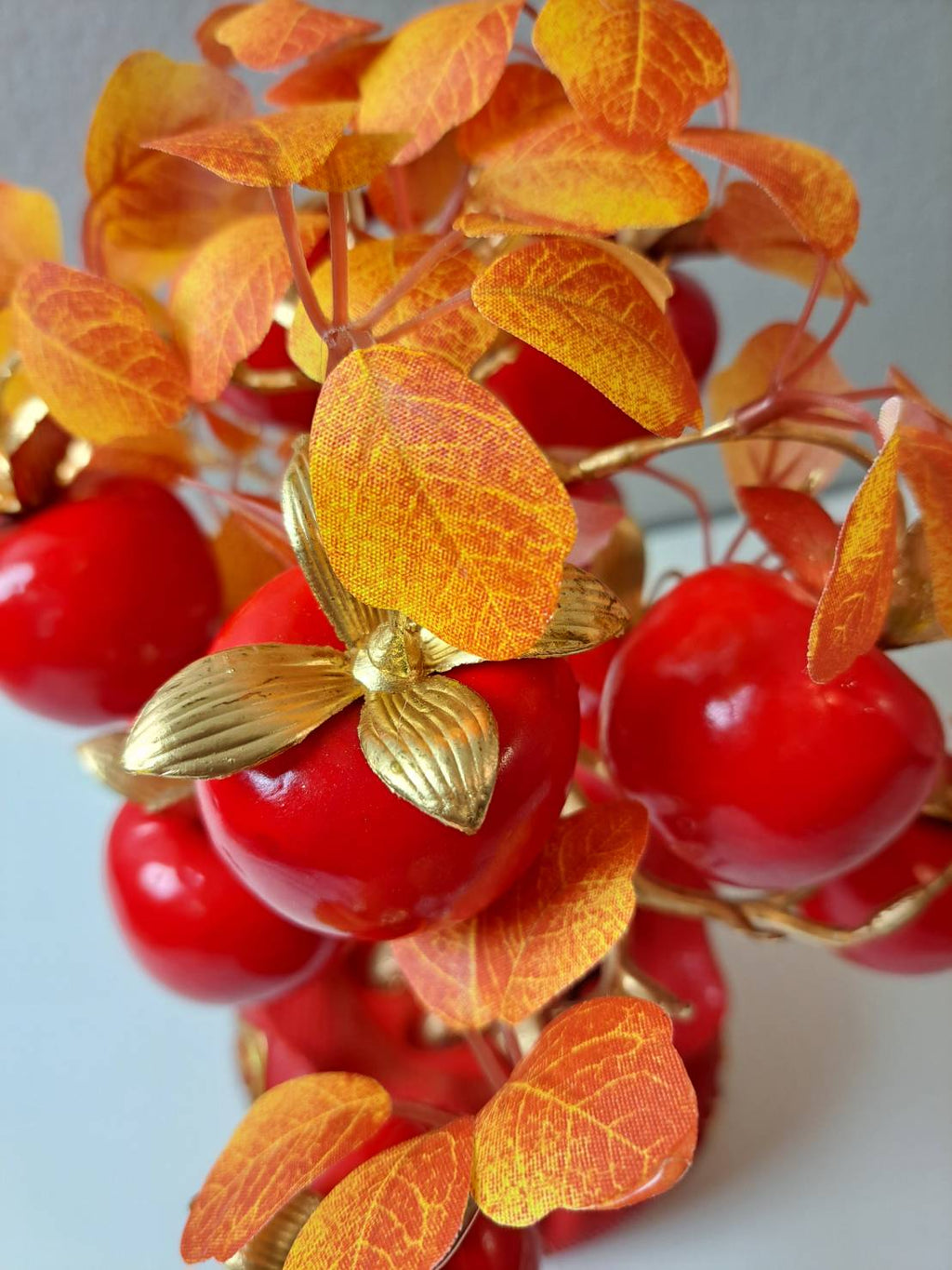Close-up of glossy faux red apples with gold leaves on Artificial Apple Tree N19