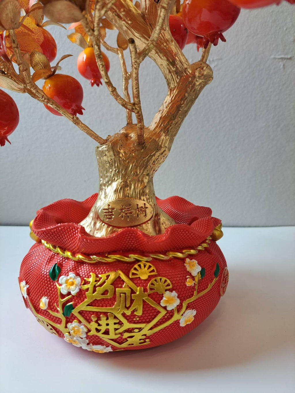Decorative red ornamental pot with gold embossed characters and blossom accents on Artificial Fruit Tree N25