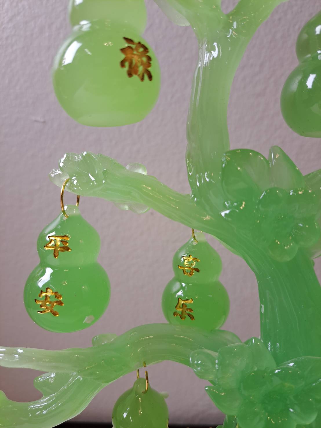 Translucent jade green gourd ornaments with gold Chinese characters 平安 and 享乐 hanging from CX622 tree branches