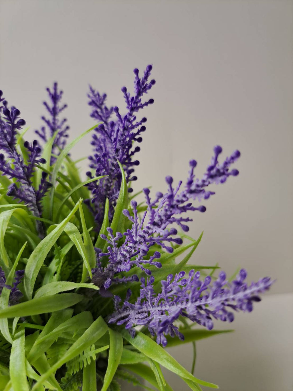 Faux lavender close-up purple blooms and green leaves
