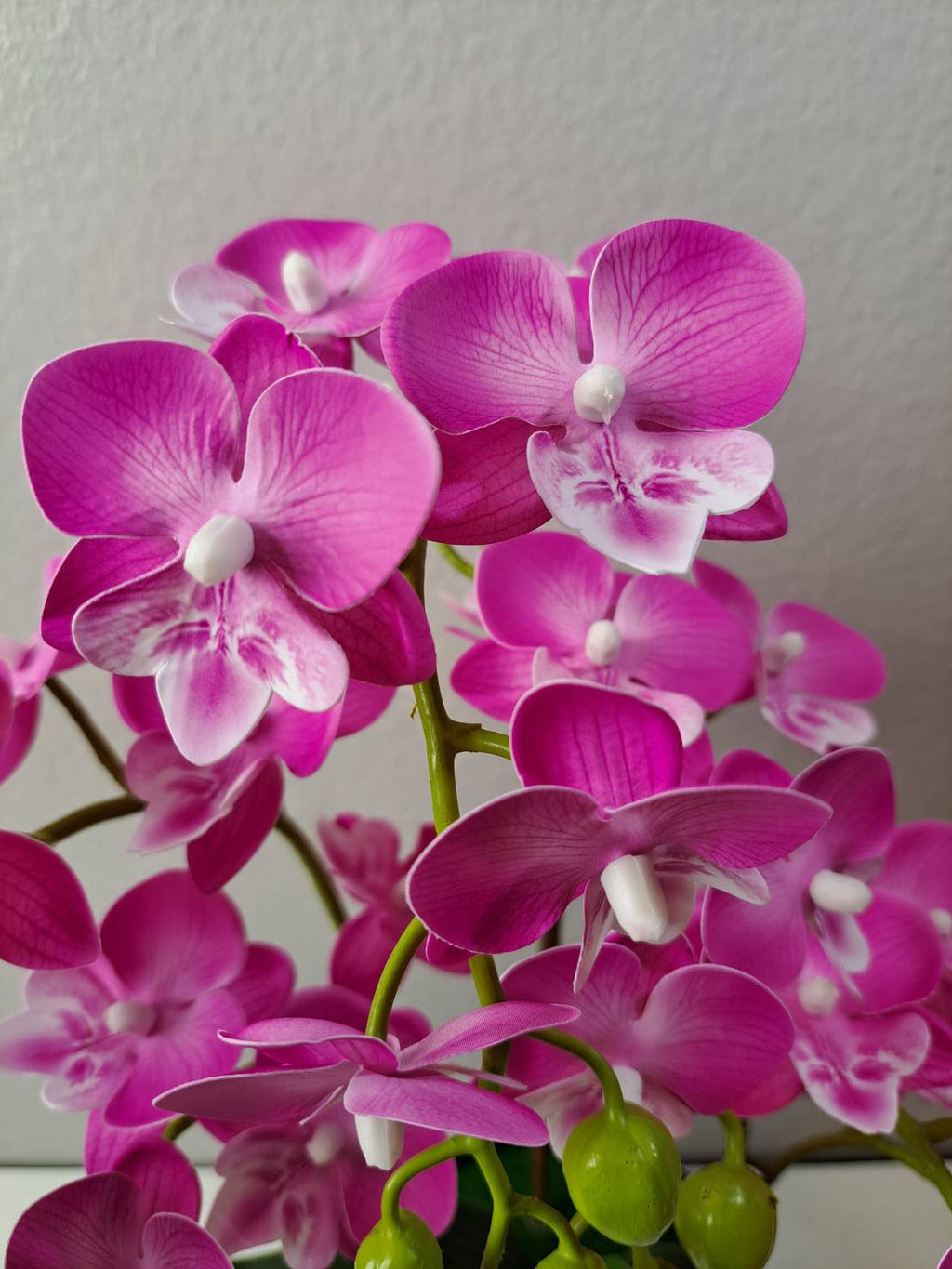 Faux magenta orchid leaves and stems in black ribbed pot