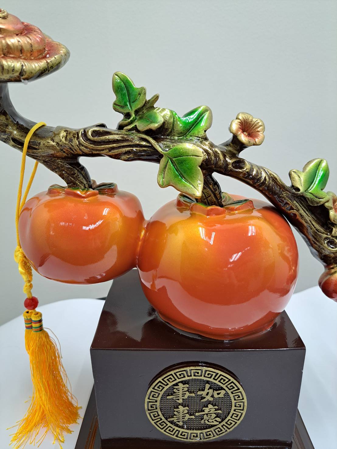 Two persimmon fruits with yellow tassel hanging from branch on ML-363 figurine