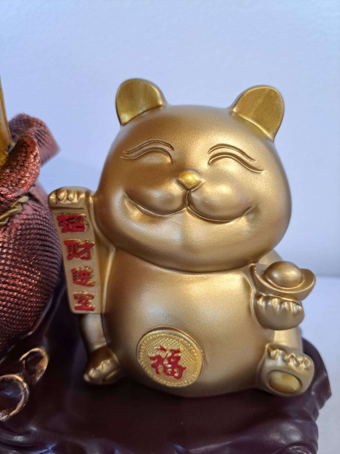 Golden Lucky Cat Figurine JF7302 - close-up of smiling gold cat holding coin and scroll