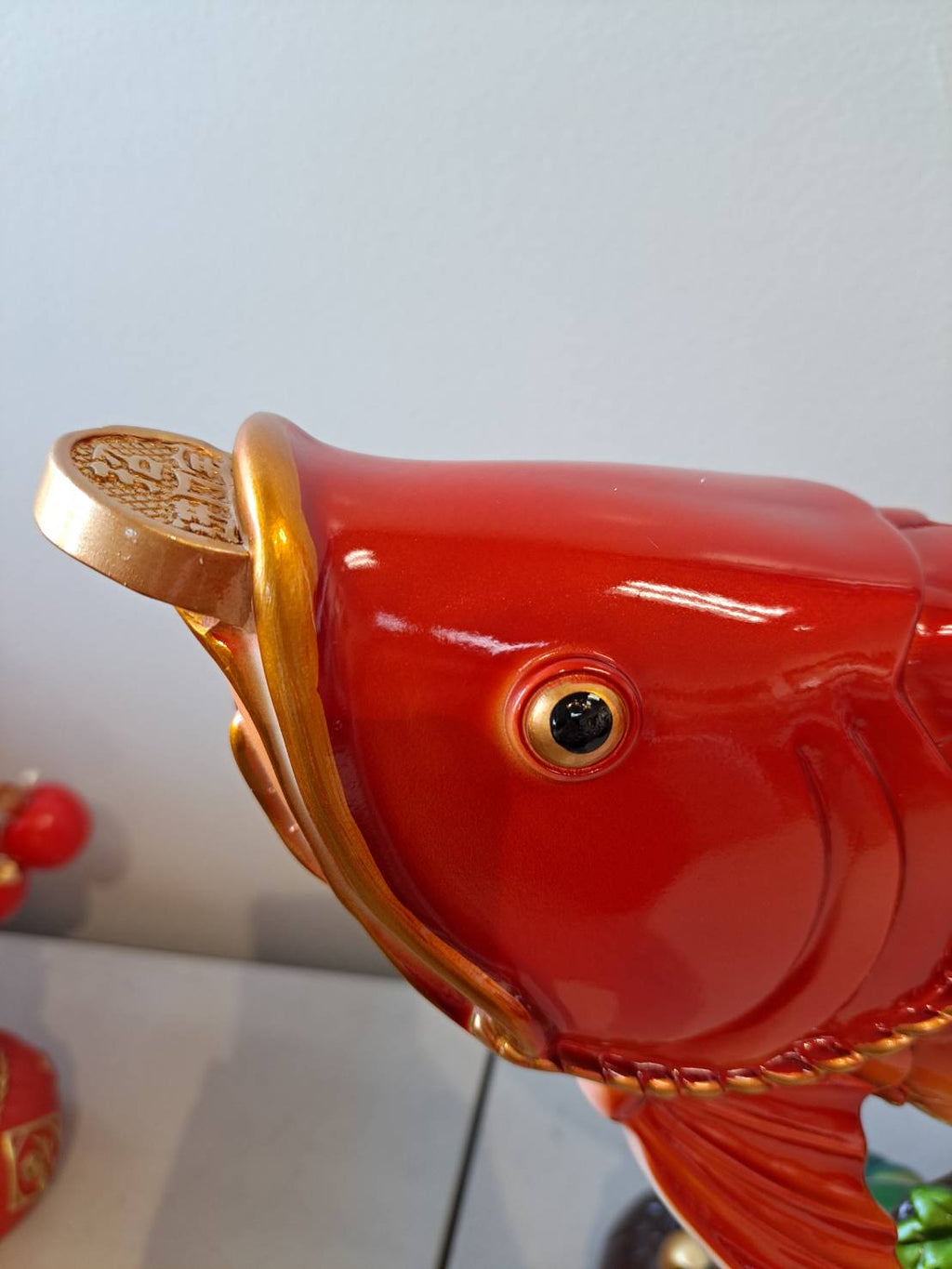 Head close-up of JF7322-2 red arowana fish statue showing gold coin in mouth and detailed eye