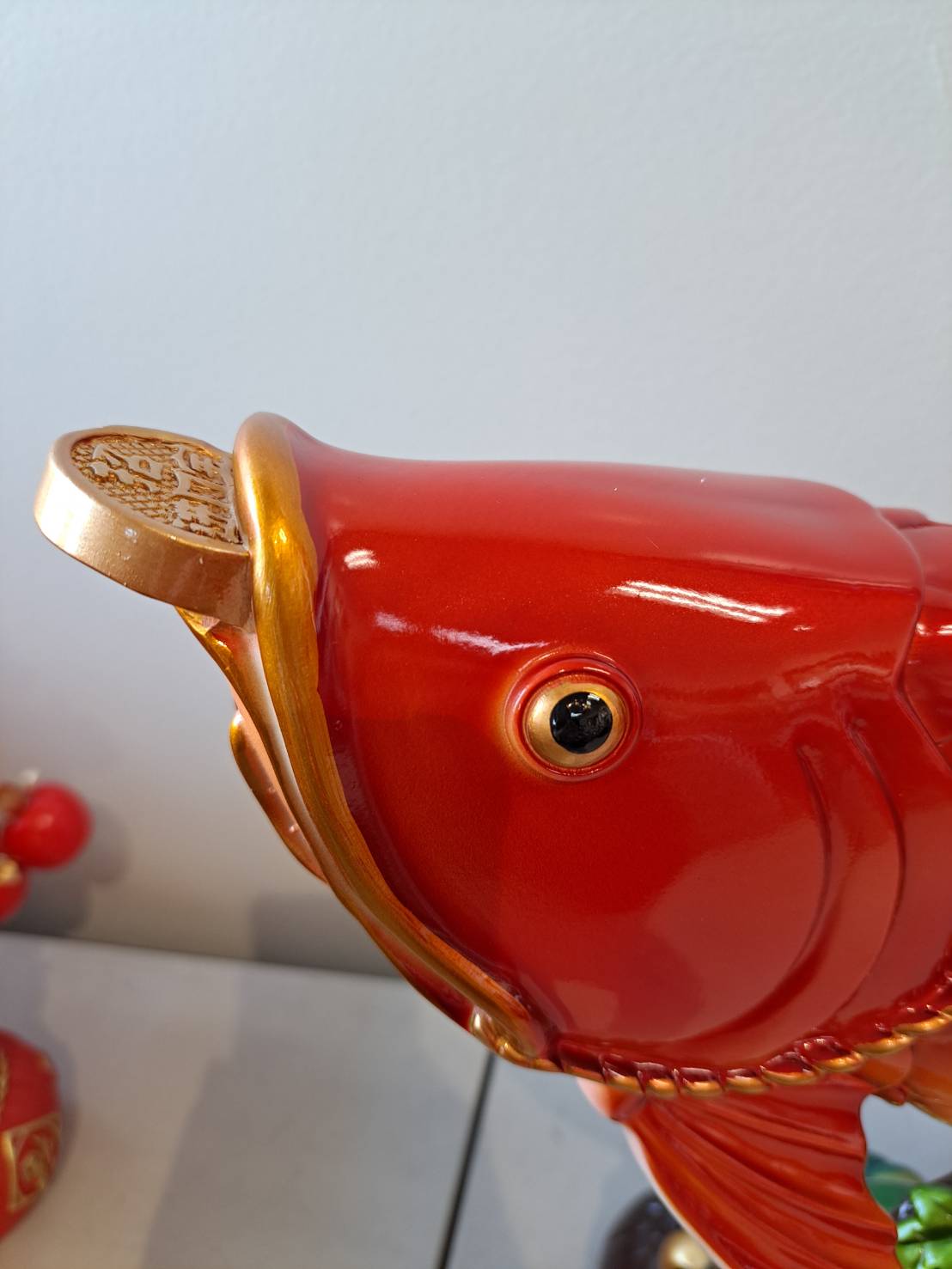 Head close-up of JF7322-2 red arowana fish statue showing gold coin in mouth and detailed eye