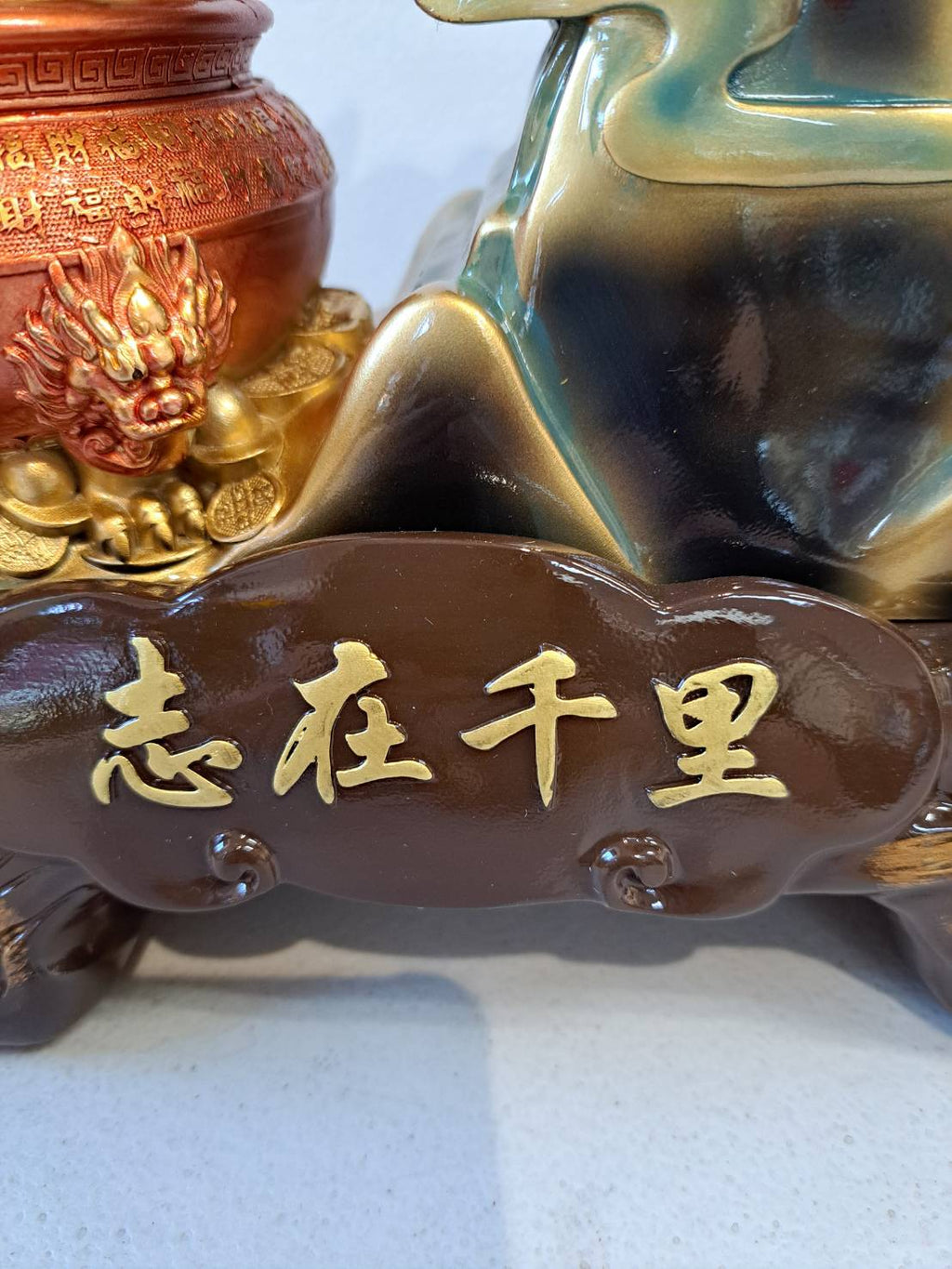 Base detail of horse statue 7358-1 showing gold ingot treasure bowl with 盈宝康 inscription and dark wood platform