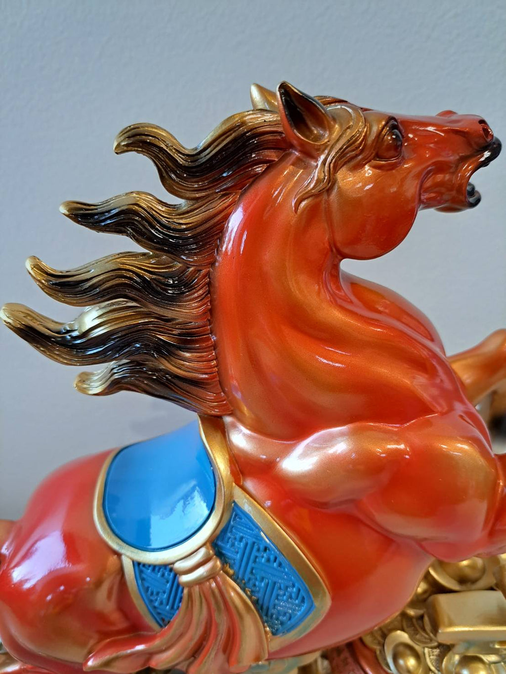 Front angle of rearing horse statue 7358-1 showing red-orange gradient glaze and blue enamel saddle detail