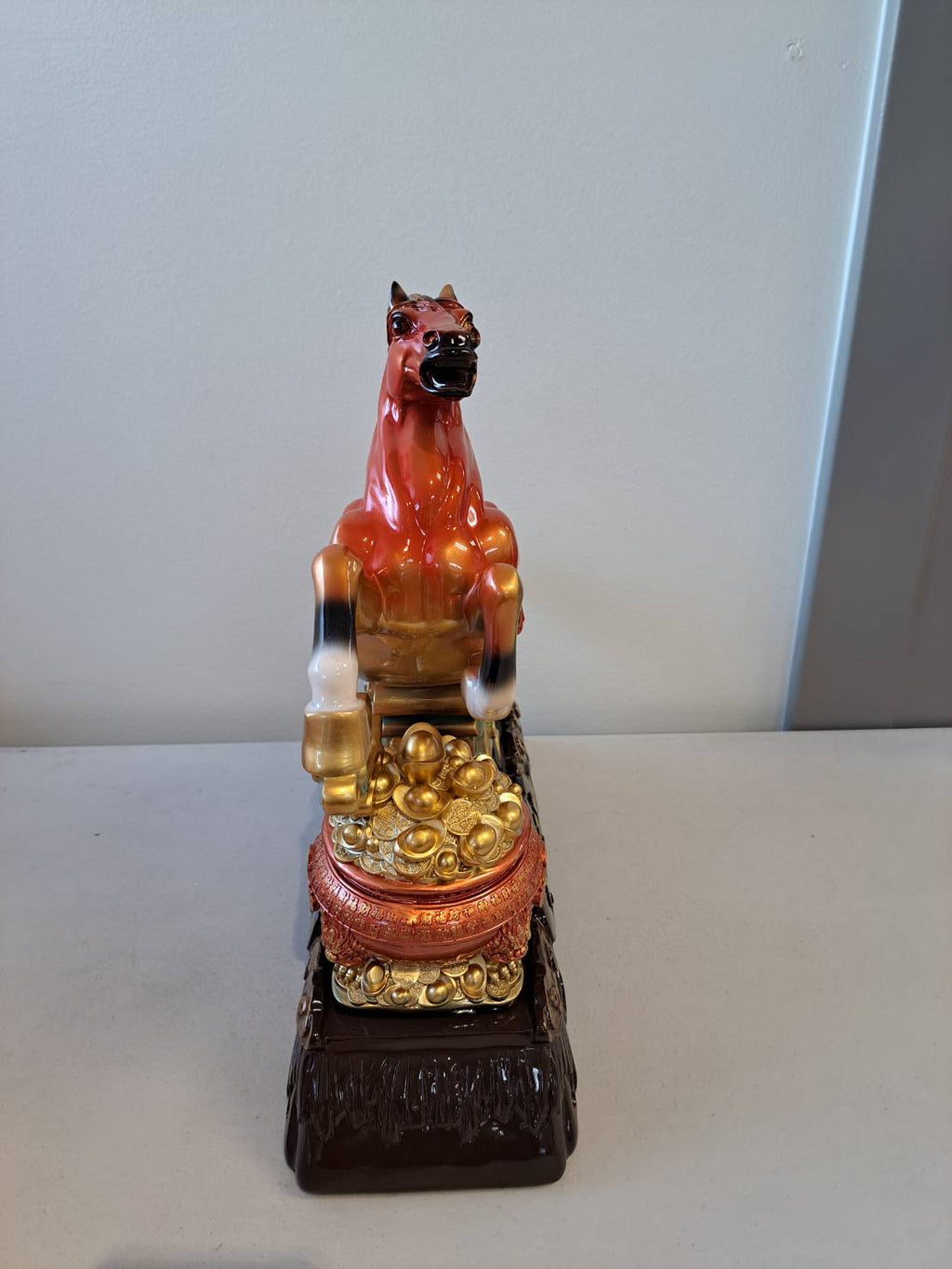 Three-quarter view of rearing horse statue 7358-1 on dark wood base with gold cloud scroll relief