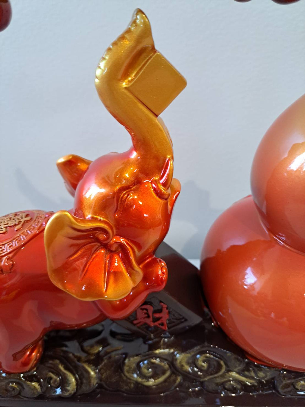 Front angle of elephant figurine 7314 showing raised trunk with gold 财 tablet and red-orange gradient glaze finish
