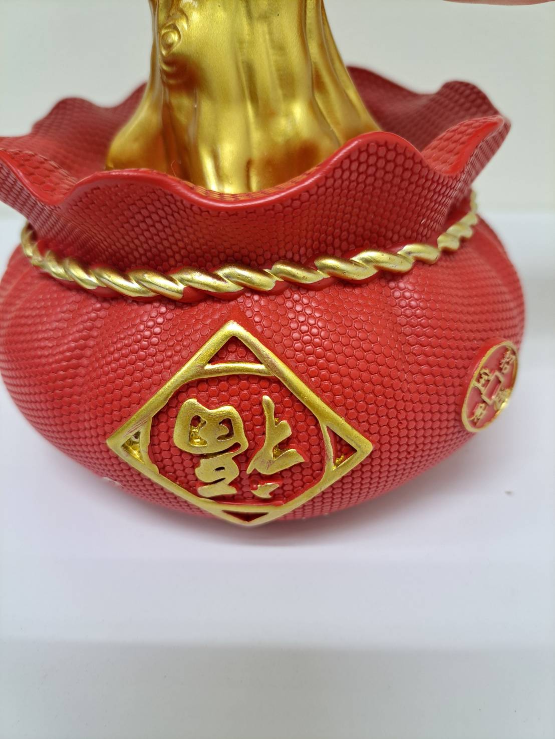 Two red persimmon ornaments with green leaves hanging from gold ring hooks on CX618