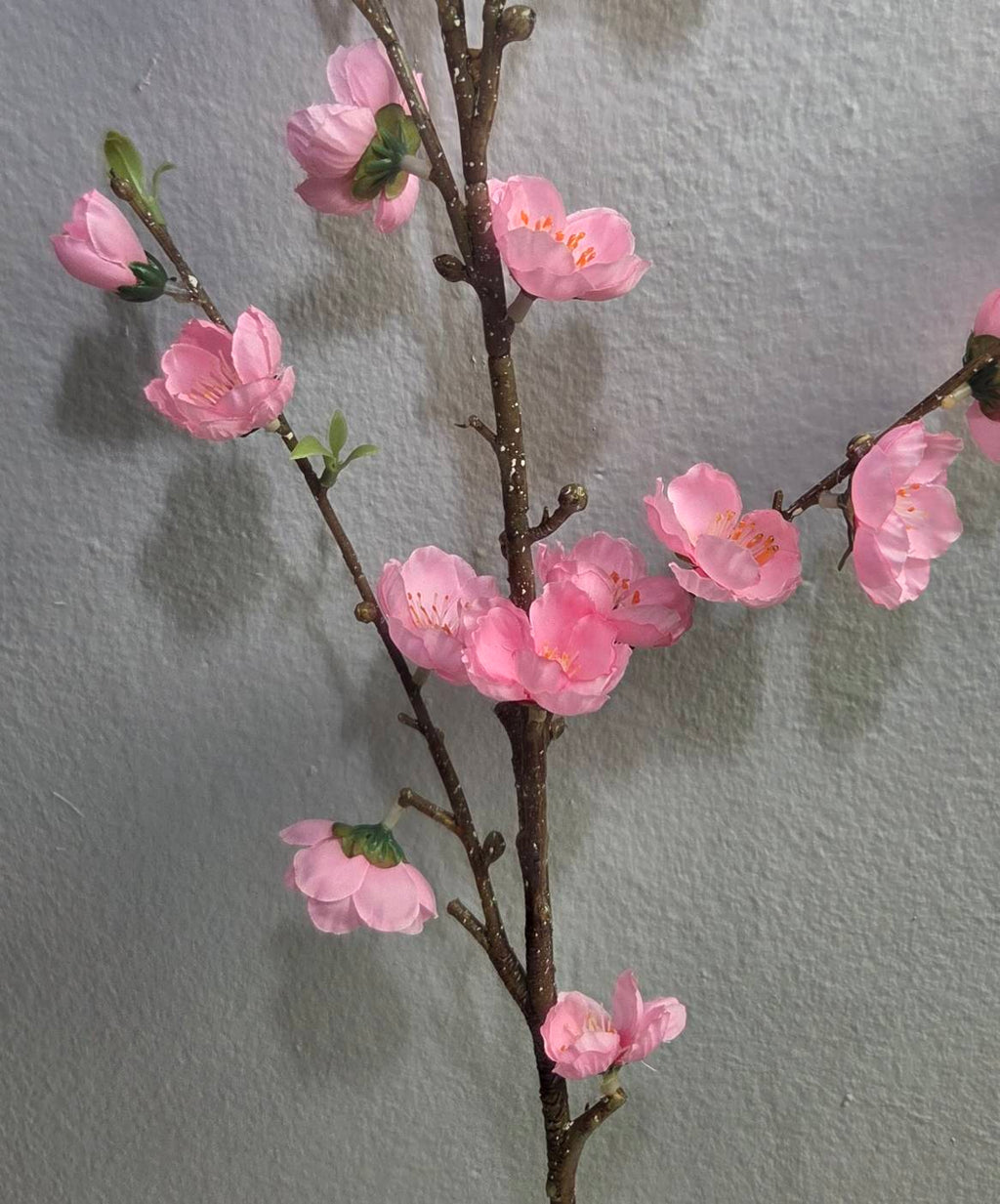 Faux pink peach blossom branch close up detail