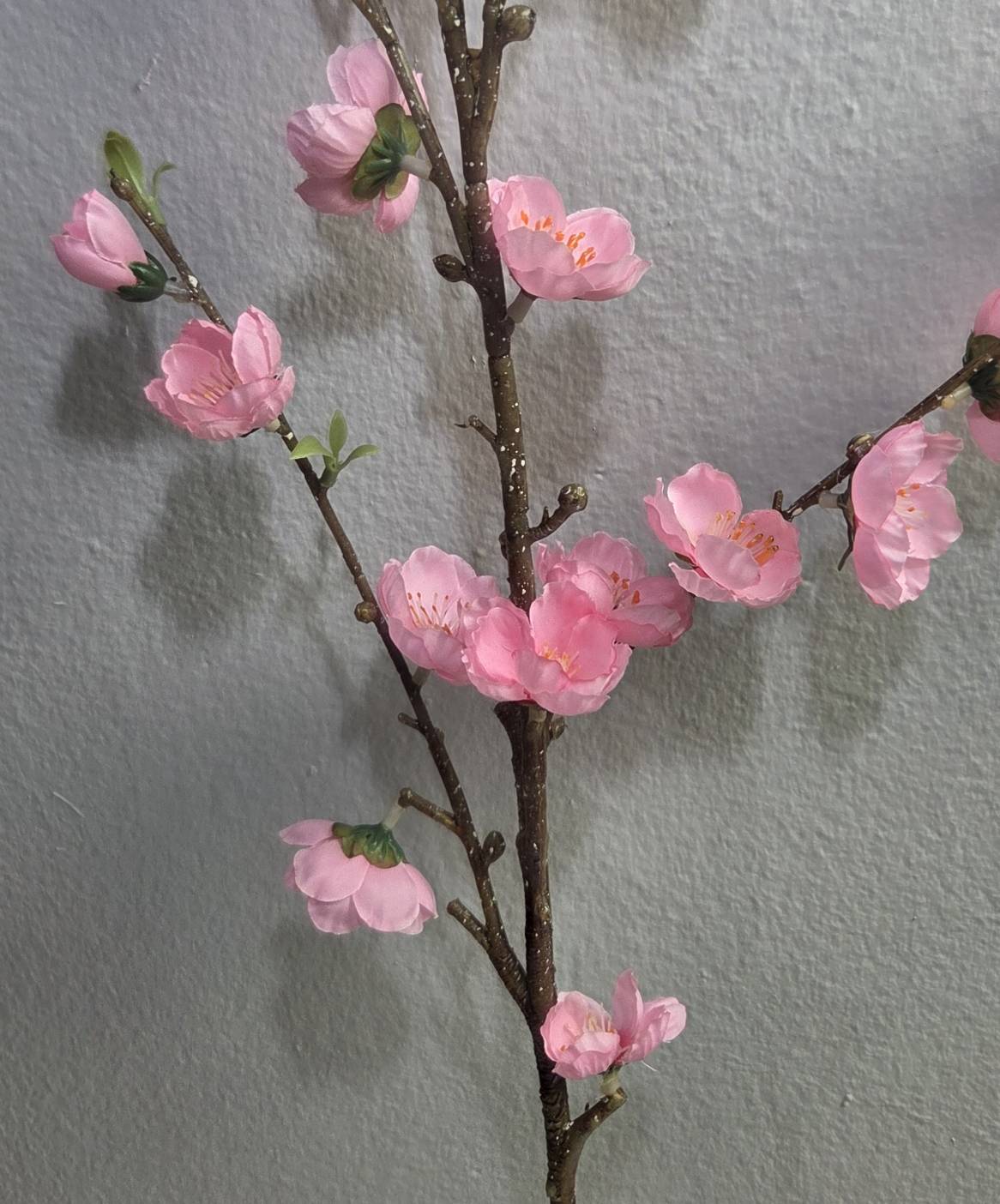 Faux pink peach blossom branch close up detail