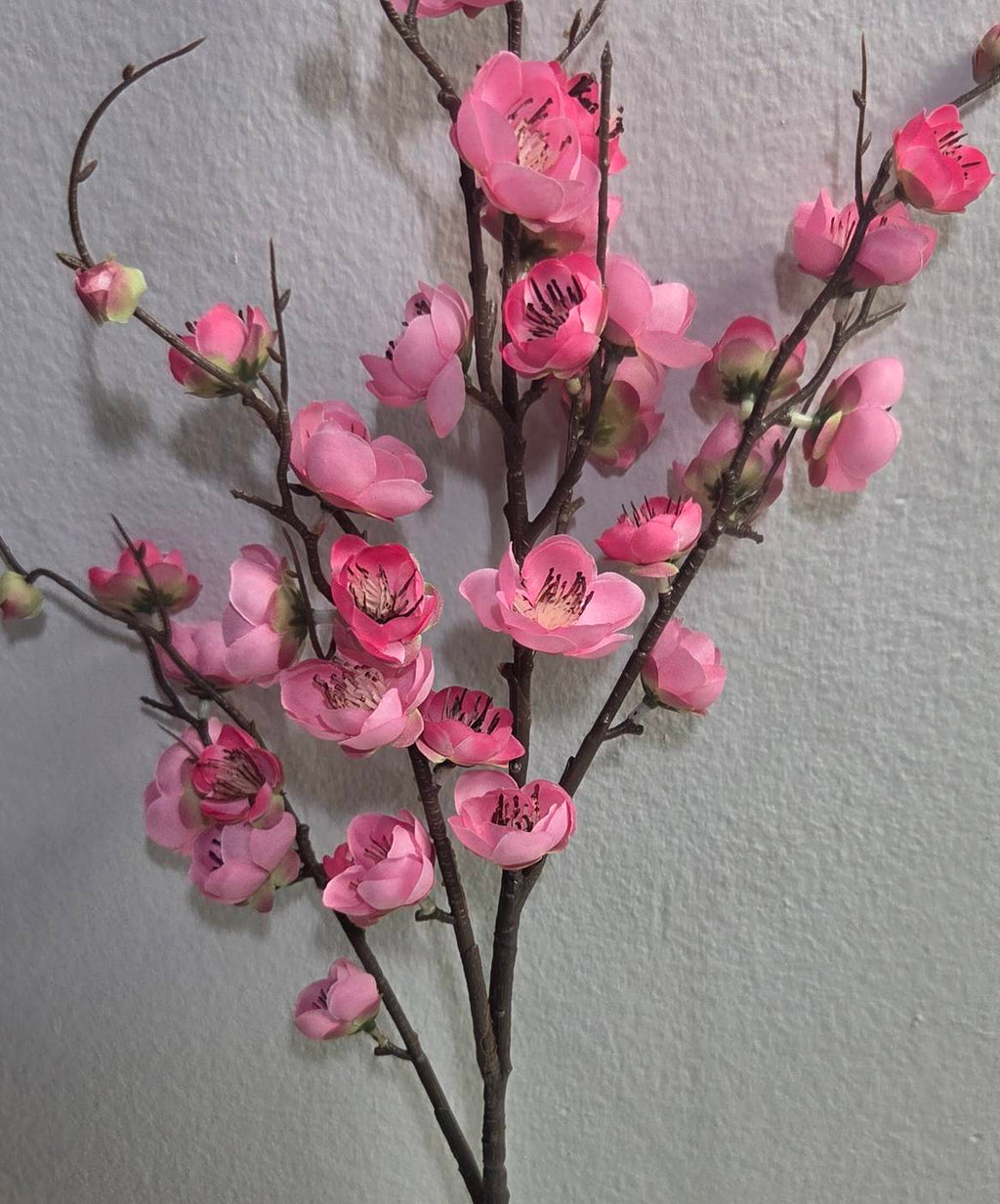 Faux pink plum blossom branch close up detail