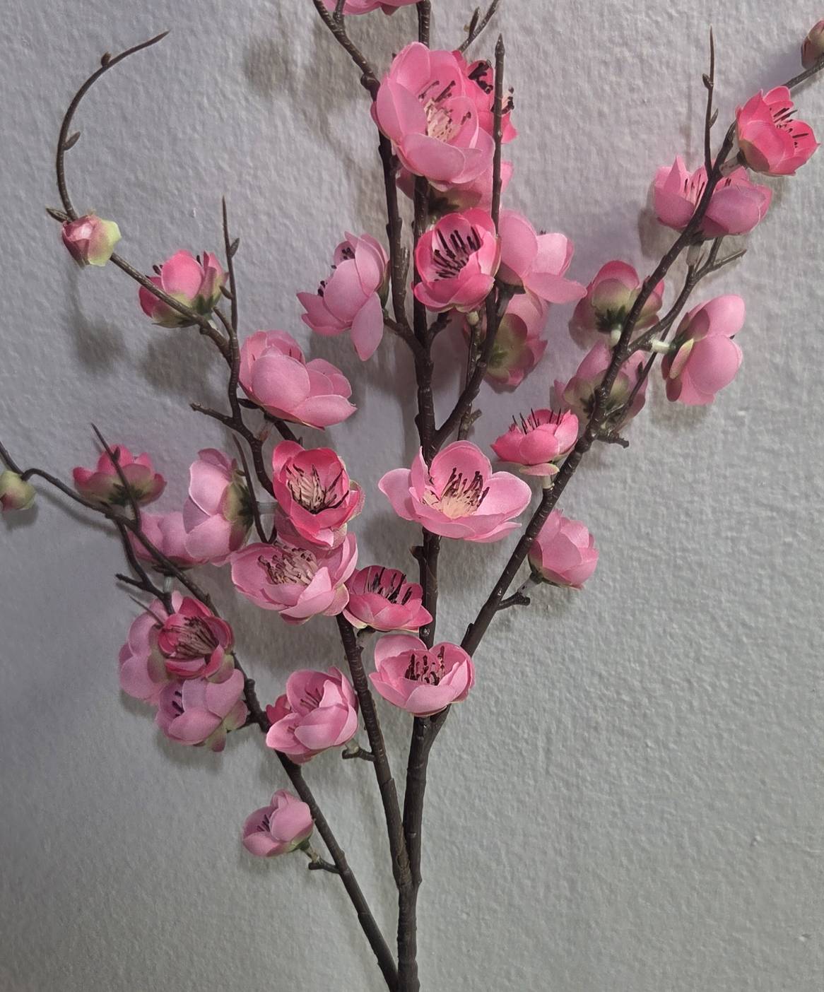 Faux pink plum blossom branch close up detail