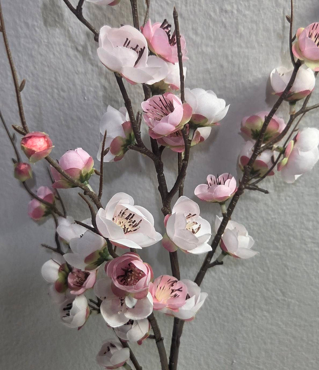 Faux white pink plum blossom branch close up detail