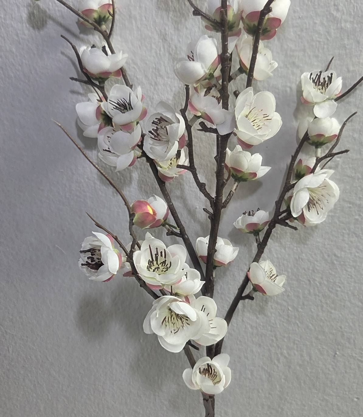 Faux white plum blossom branch close up detail