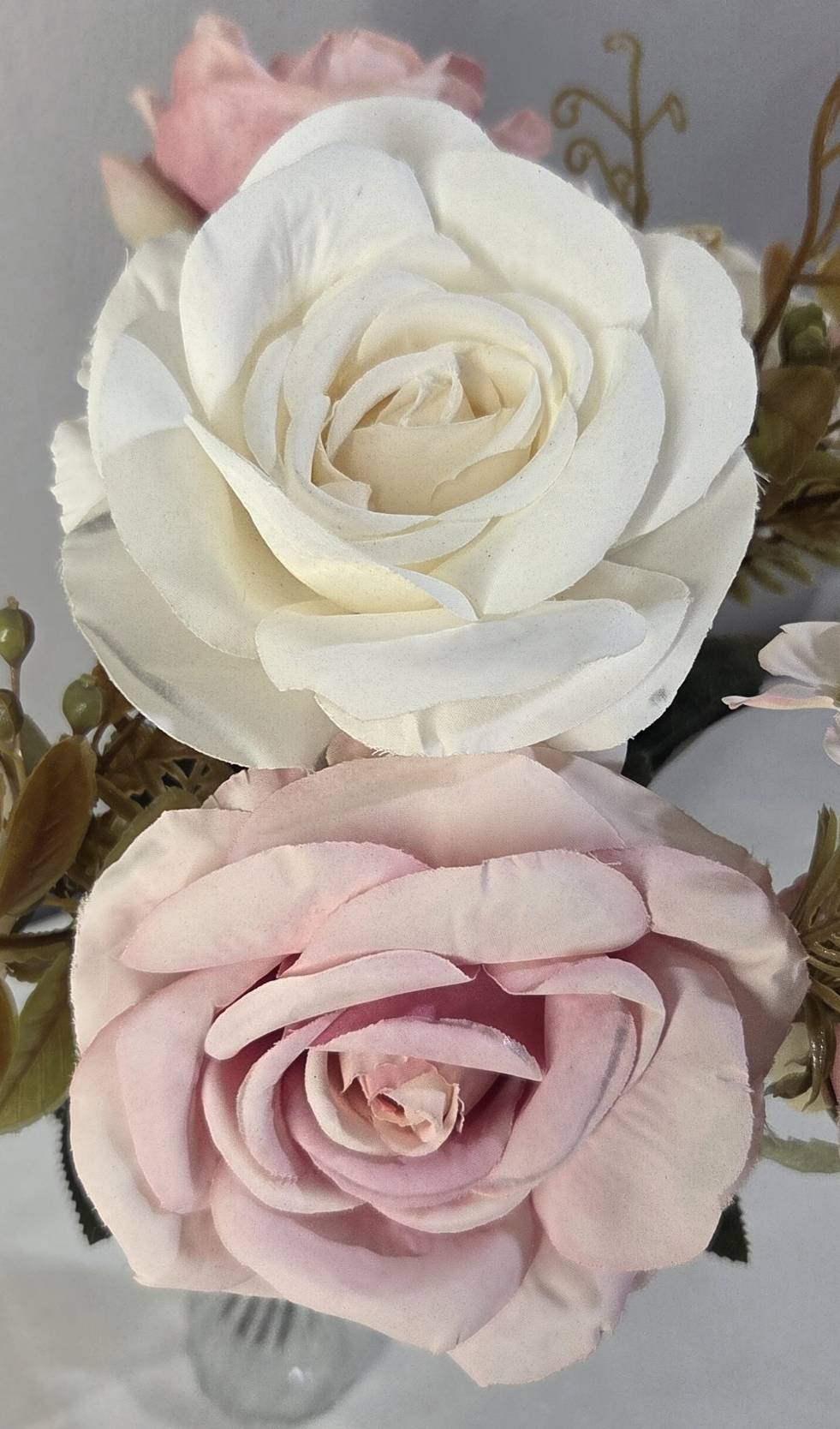 Close-up of faux dusty mauve rose showing detailed fabric petal texture and spiral center