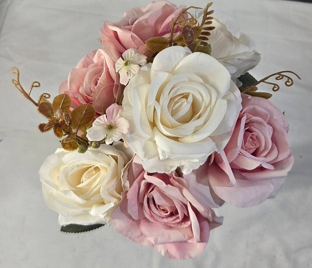 Faux white and pink rose bouquet displayed on white bookshelf with gold decor accents and coffee table books