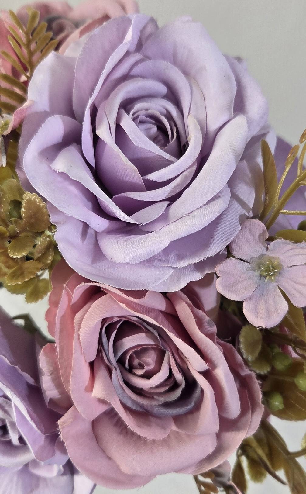 Close-up of faux lavender rose and dusty mauve rose blooms showing detailed layered fabric petal texture