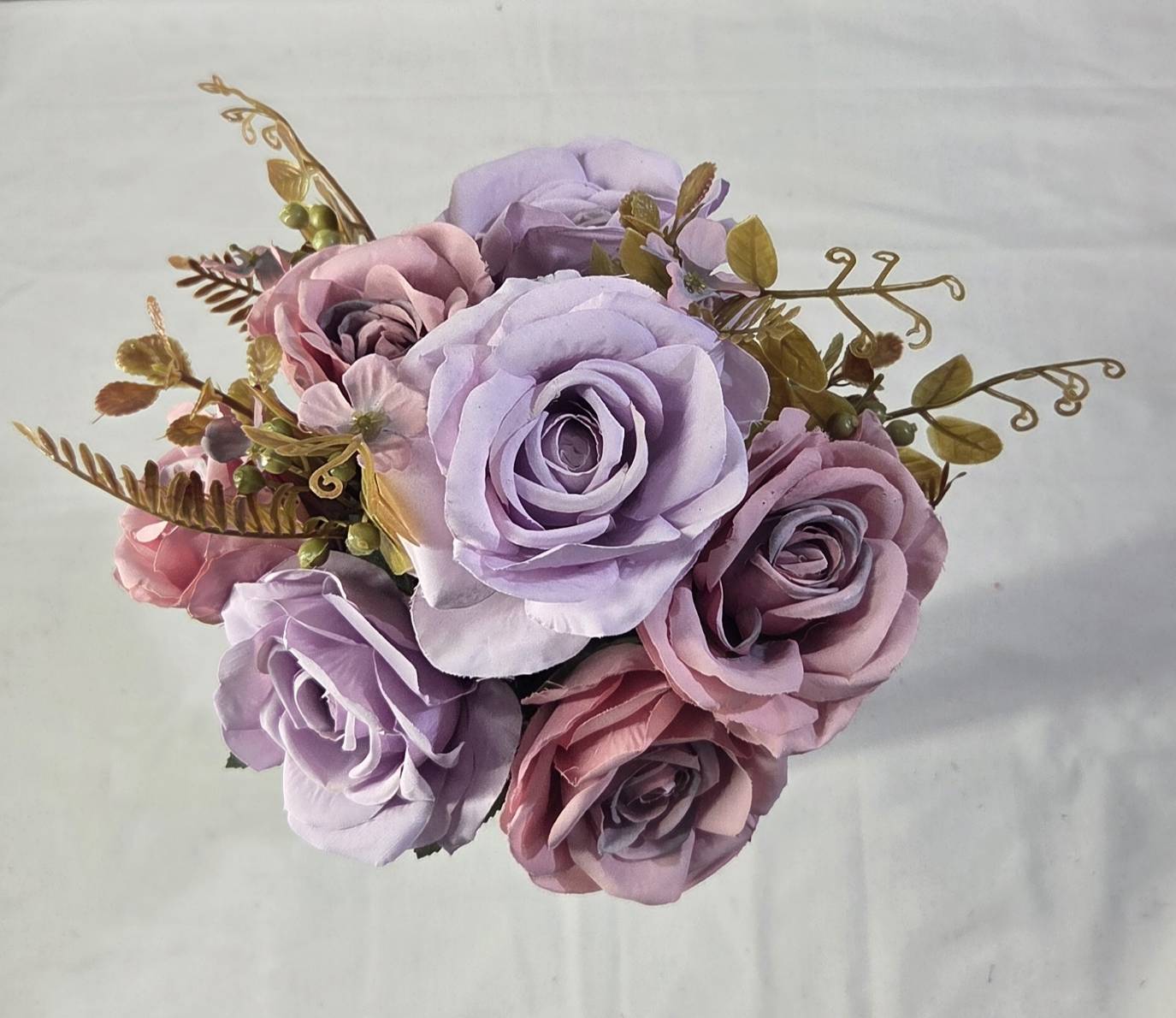 Top view of faux lavender and dusty mauve rose bouquet showing full bloom arrangement with golden tendrils and olive foliage