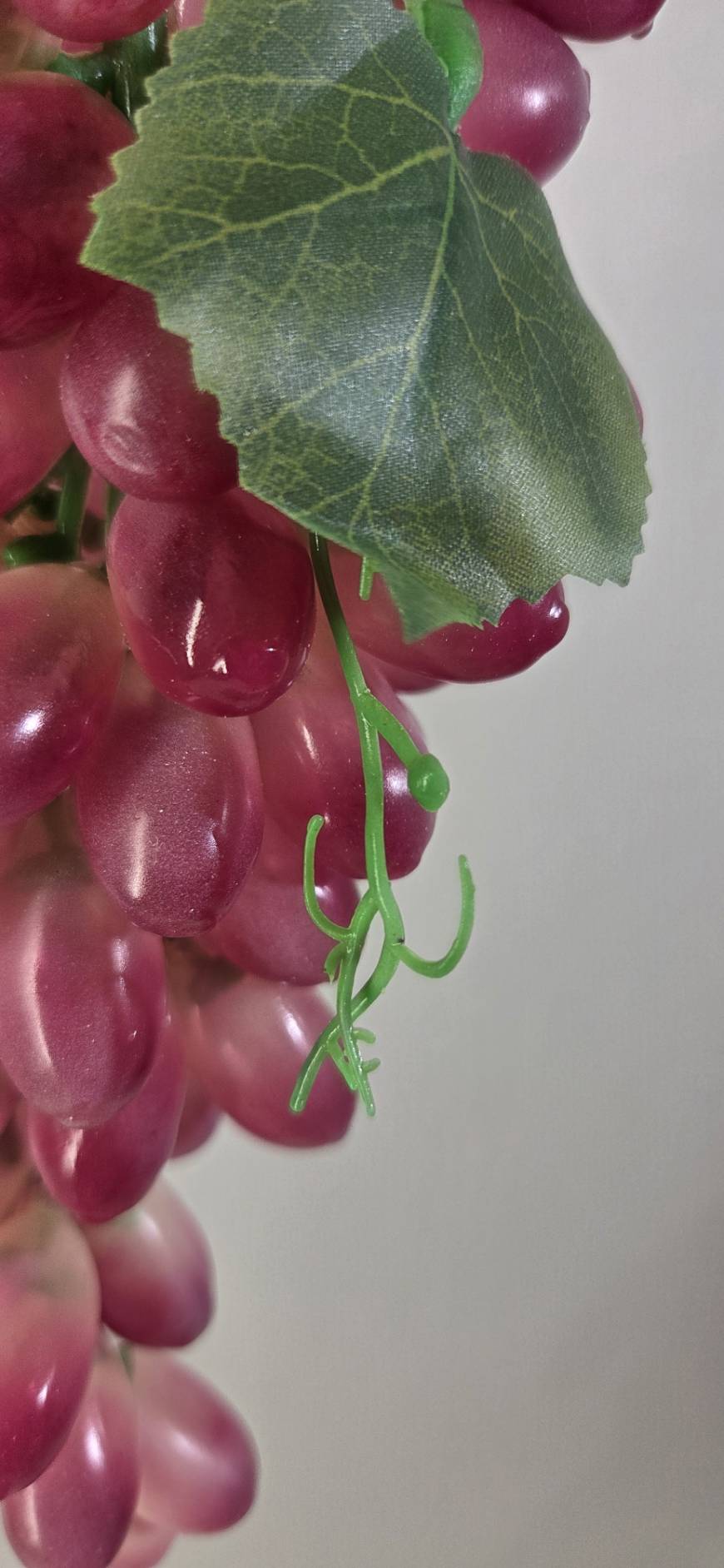 Faux Red Grape Cluster GRT-01 leaf detail - textured green faux vine leaf with visible veining against red grape cluster