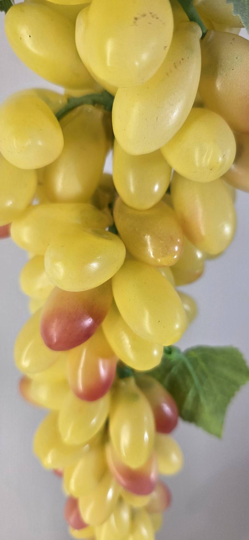 Faux Yellow Grape Cluster GRT-03 close-up - glossy yellow oval grapes with blush pink tips and green faux vine leaf