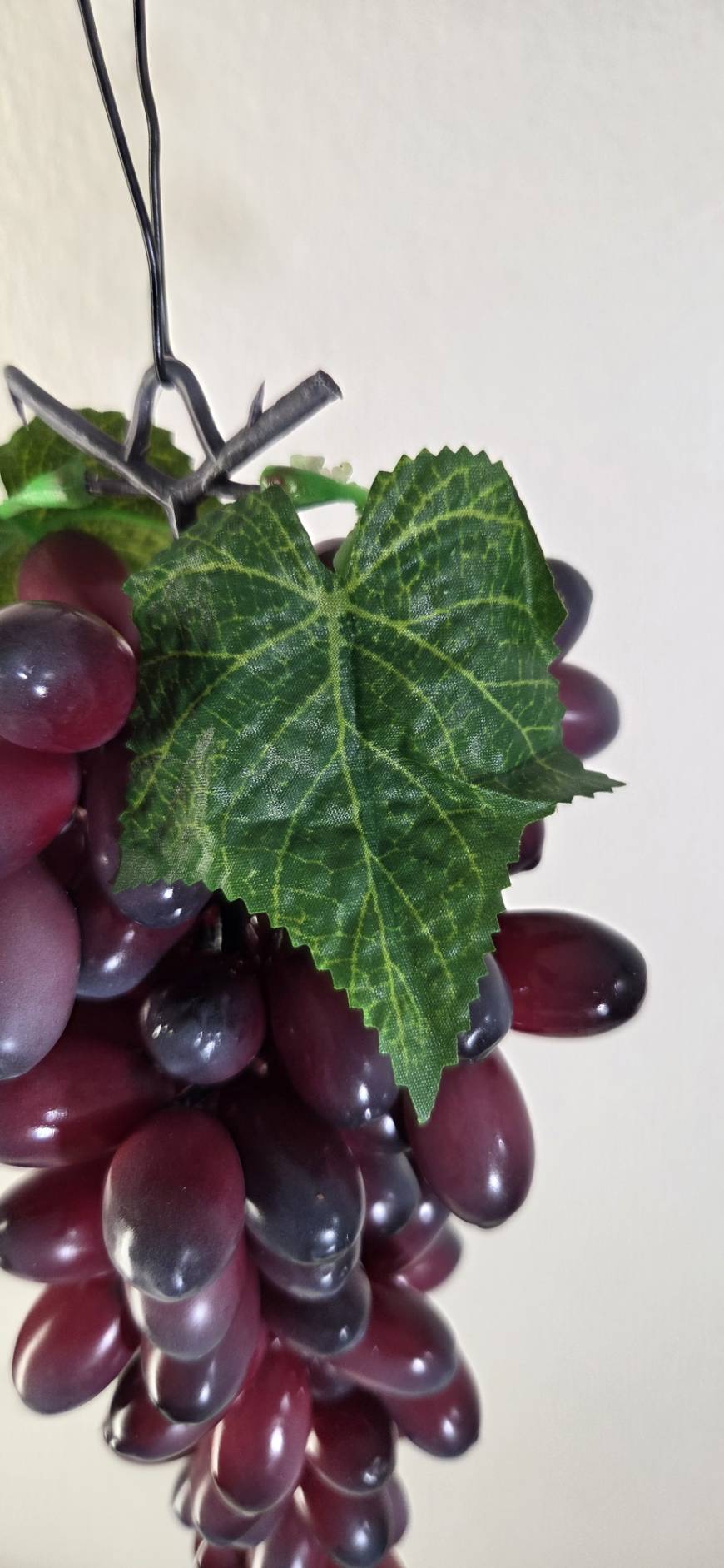 Faux Dark Purple Grape Cluster GRT-04 leaf detail - textured green faux vine leaf with visible veining against dark purple grape cluster and metal hook hanger