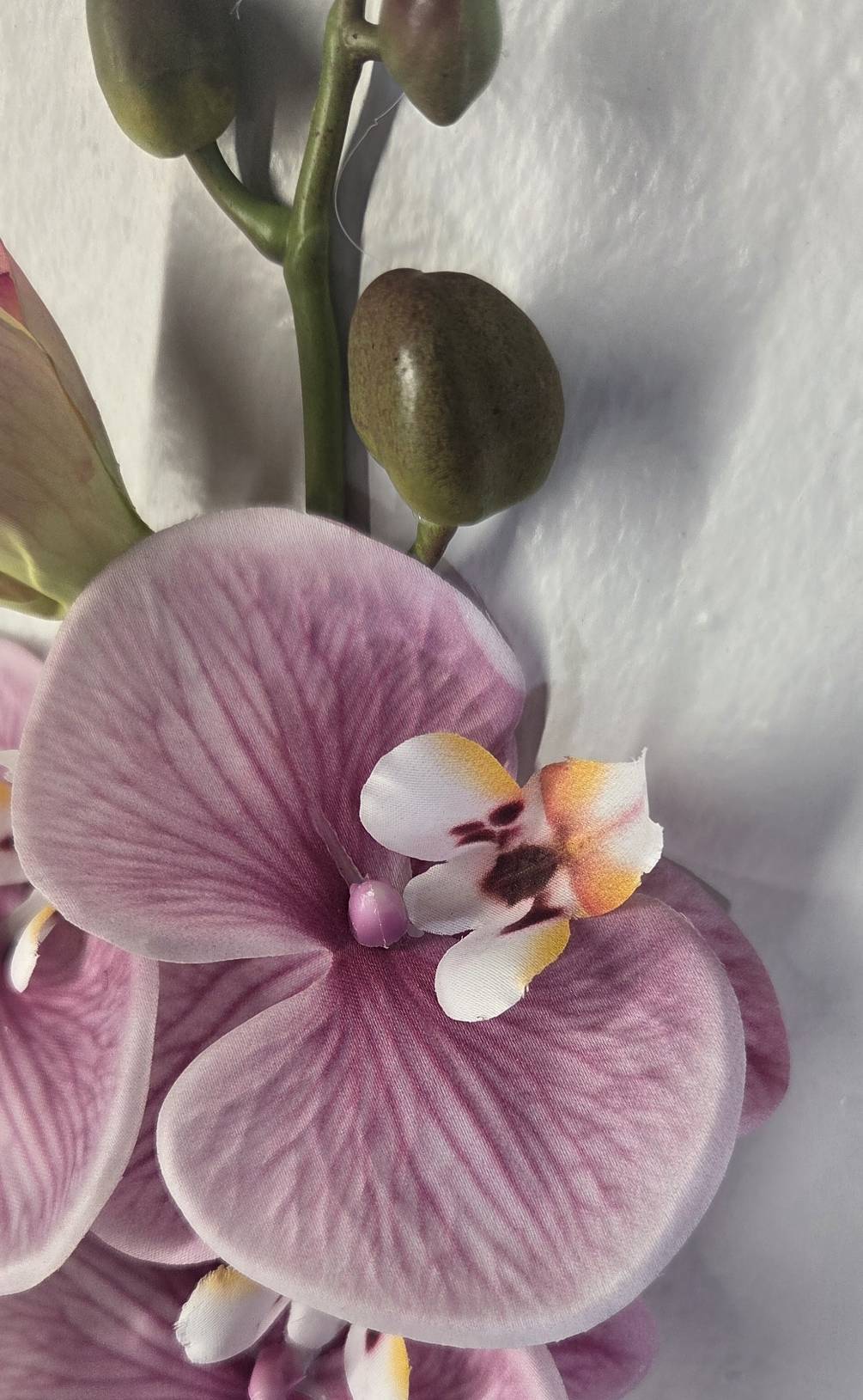 Faux Mauve Phalaenopsis Orchid Stem ORE-02 - styled in tall glass cylinder vase in luxury hotel lobby