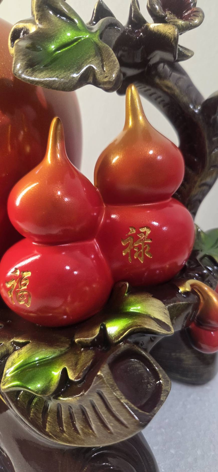 Close-up of two red gourd figurines inscribed with gold 福 and 禄 characters on statue 7279