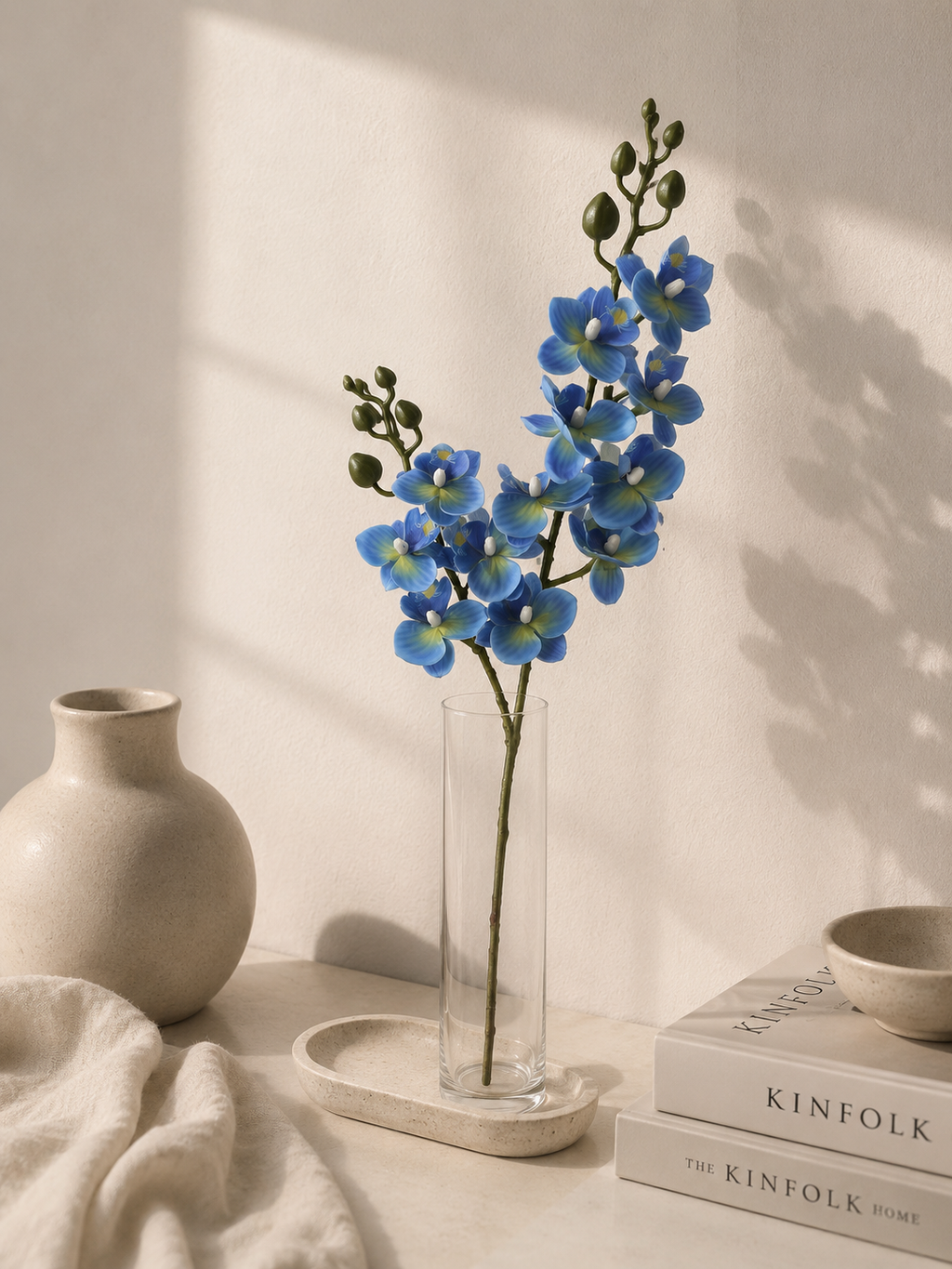 Faux Blue Phalaenopsis Orchid Stem OCT-03 - styled in glass vase on white table with ceramic decor