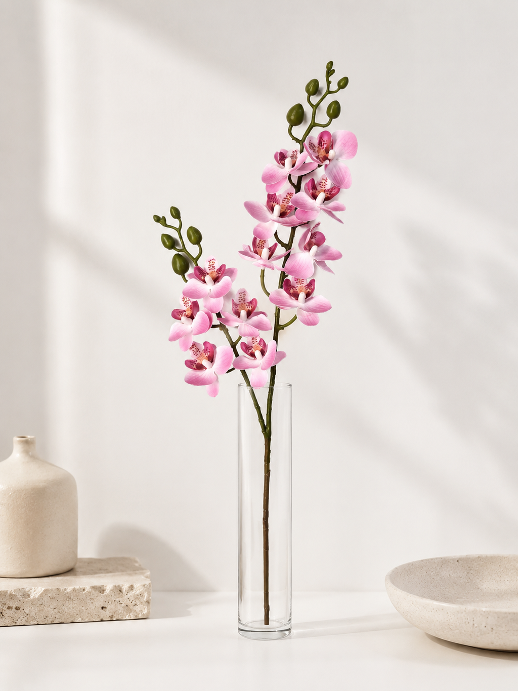 Faux Light Pink Phalaenopsis Orchid Stem OCT-05 - styled in tall glass vase on white table with ceramic decor