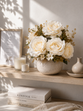 AI lifestyle render of faux ivory white rose bouquet in stone round vase styled on wooden shelf with candle and Kinfolk books