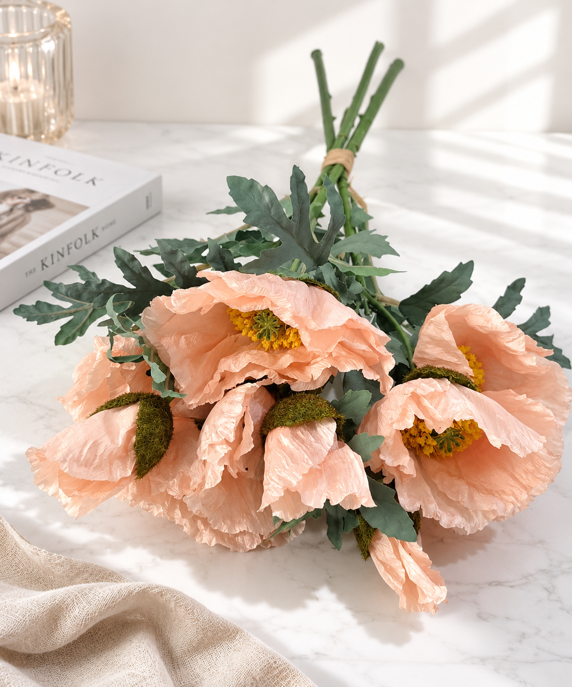 Faux peach poppy bouquet PPY-02 styled on marble surface with candle and Kinfolk book - lifestyle decor