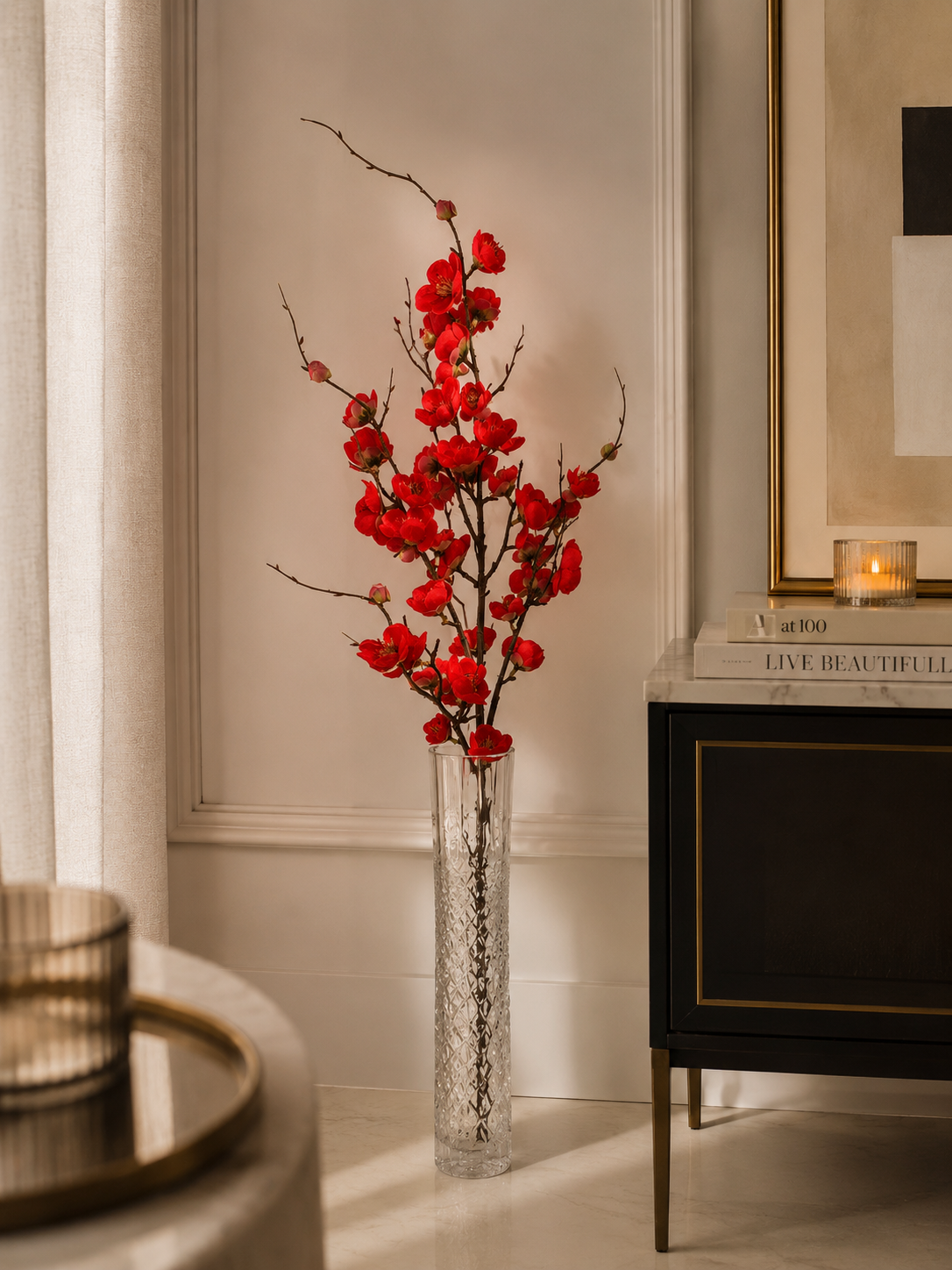 Red plum blossom branch in tall glass vase - lifestyle