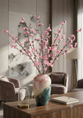 Pink peach blossom branches in decorative vase - living room lifestyle